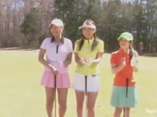 Perky asiatiskapojke tonårs flickor spela en spel av remsan golf